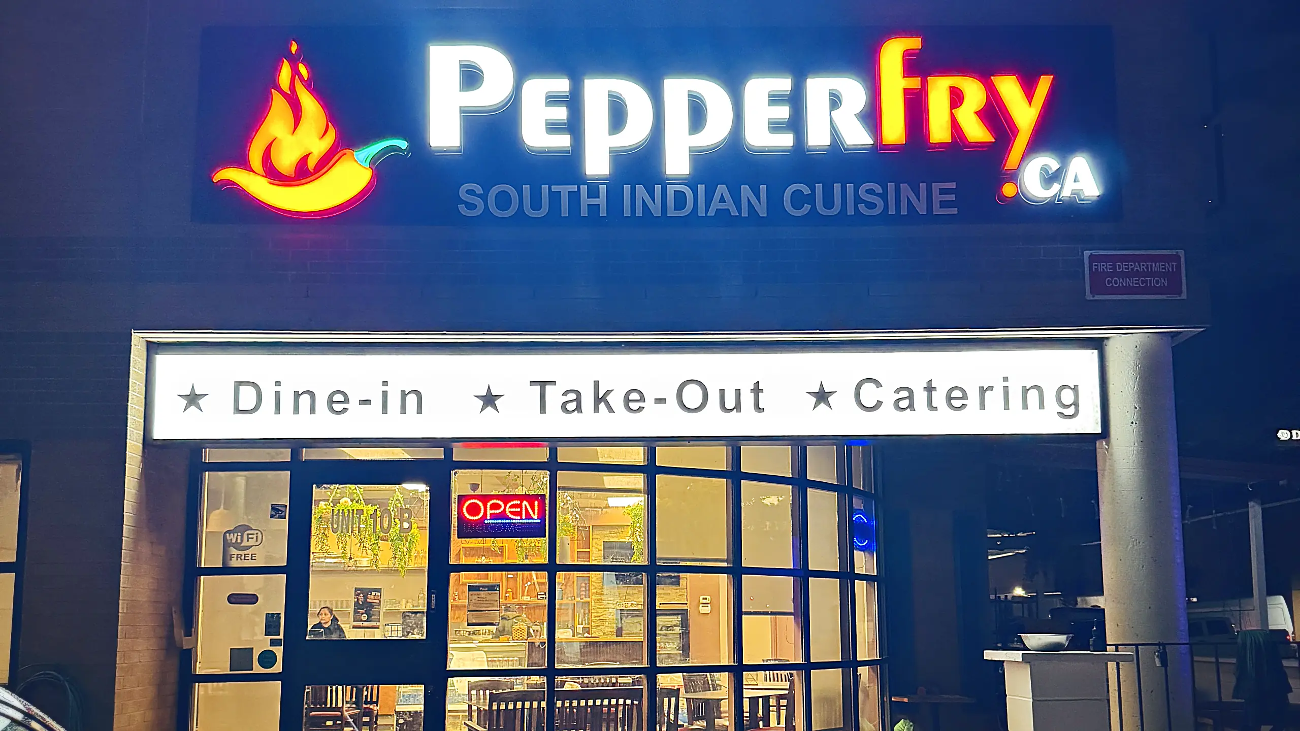 pepperfryca.ca South Indian Cuisine storefront at night, with the lit sign and Dine-in, Take-Out and Catering banner